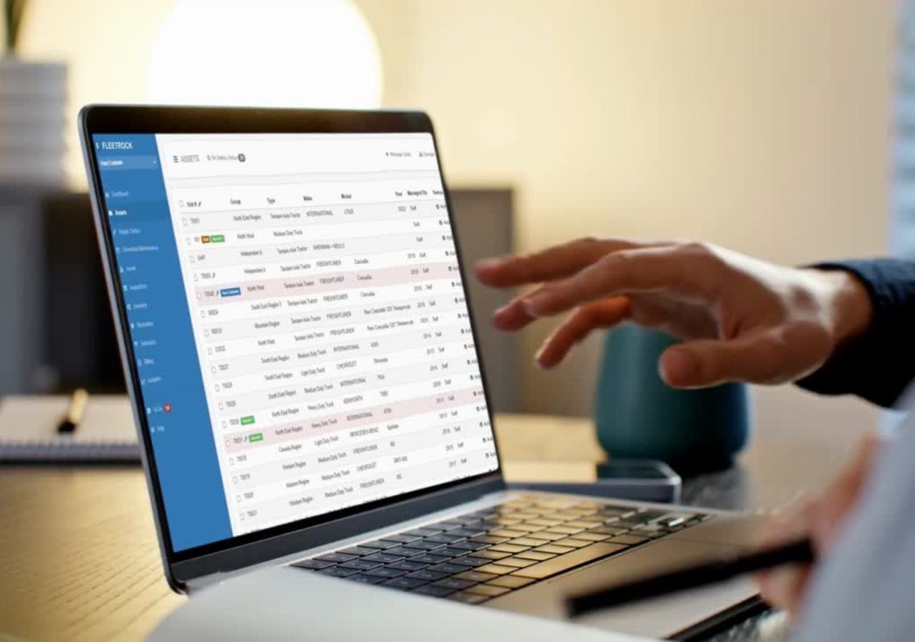 Fleet manager reviewing the Fleetrock assets list showing vehicle groups, types, makes, and models